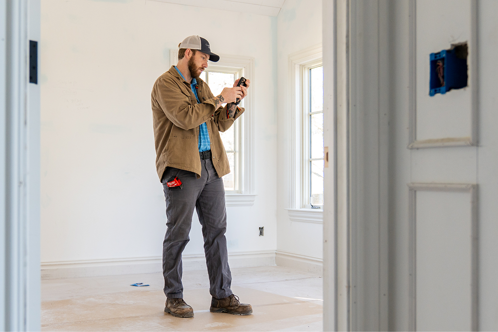 Team member from CopeGrand Homes at a construction site taking notes