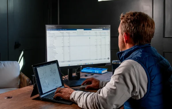 Man looking at two screens