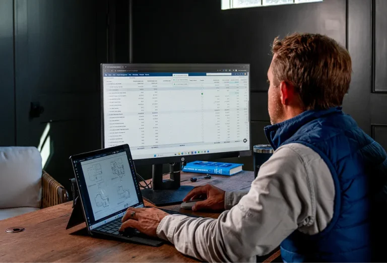 Man looking at two screens