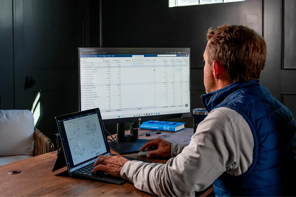 Man looking at two screens