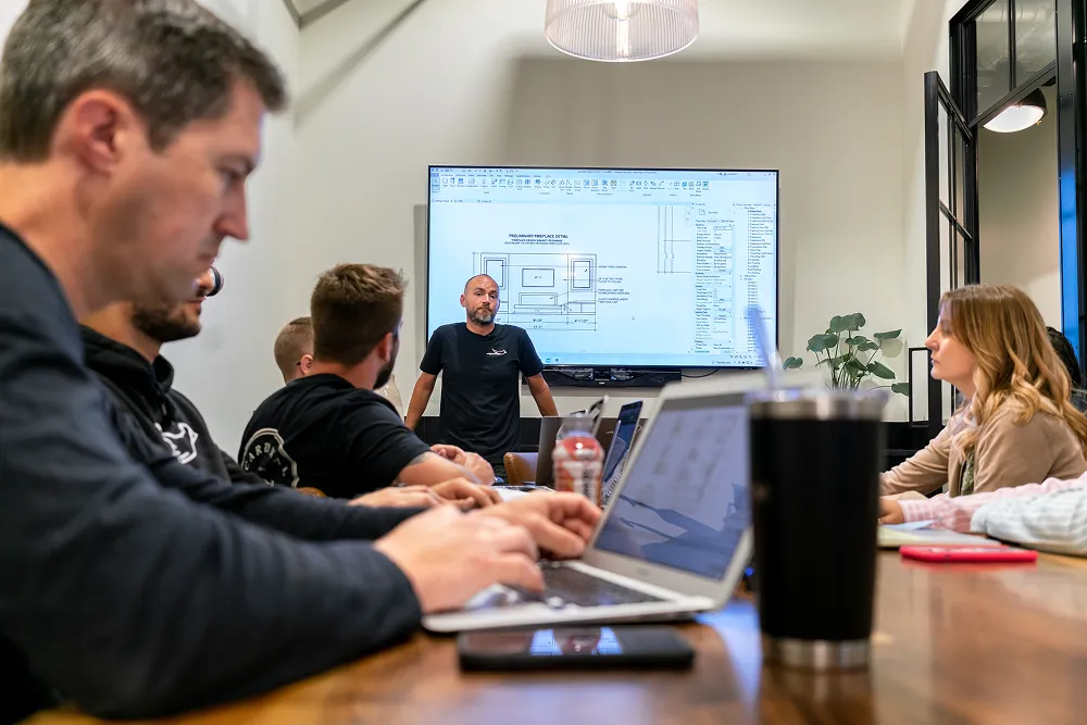 Man working on laptop during a team meeting