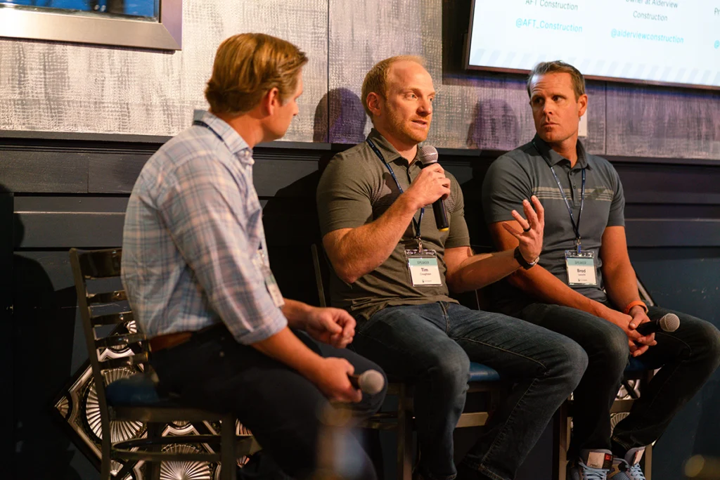Construction industry professionals participating in a panel discussion at a Buildertrend event.