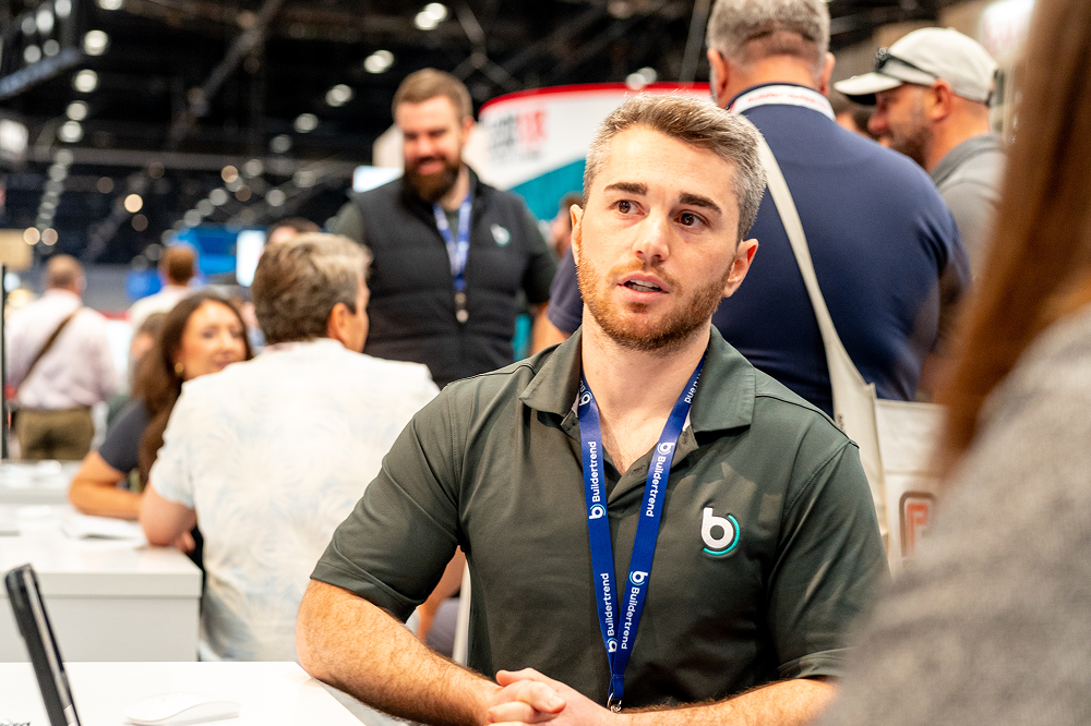 IBS 2027 21 Buildertrend team member speaking with an attendee at the International Builders' Show.