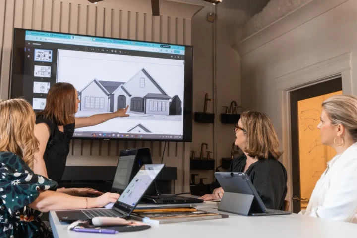 Construction professionals reviewing custom home plans during a project planning meeting.