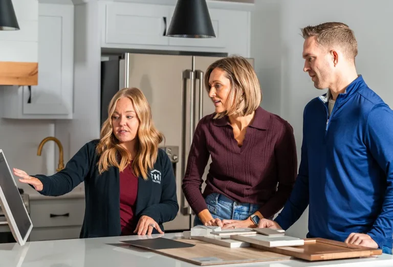 Three construction sales team members looking at a screen in home kitchen